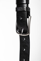 Wall Mural - Black leather belt for trousers and jeans. Fastened fashionable men leather belt with dark chrome matted metal buckle isolated on white background. Male accessory. Luxury strap. Haberdashery goods