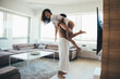 © oneinchpunch - Young couple lifestyle moments at home. Playful young woman and man having fun in a beautiful luxury penthouse loft apartment