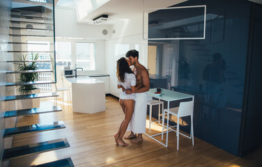 Wall Mural - Young couple lifestyle moments at home. Playful young woman and man having fun in a beautiful luxury penthouse loft apartment