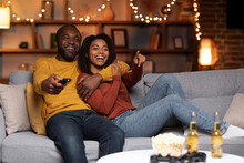 Joyful African American Couple Watching TV Together At Home