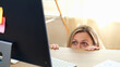 © megaflopp - Woman hides behind office desk and looks at computer monitor.