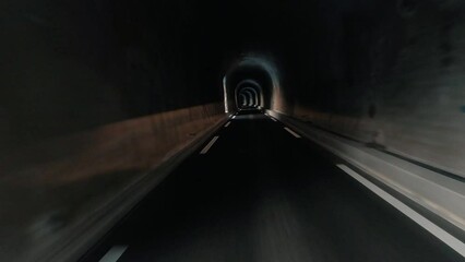 Wall Mural - Vehicle perspective of car traveling inside dark tunnel gallery. Concept of automobile or truck driving in dark freeway during a journey. Light in background. Auto trip on the road