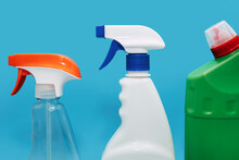 Various Spray Bottles With Detergent On A Blue Background. The Concept Of Cleaning And Disinfection Of An Office Or Residential Space. Sprayers For Cleaning Various Surfaces