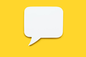paper speech bubble in the shape of a rectangle on a yellow background. flat white chat icon in the 