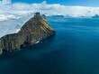 prominent cliff in the foreground with a breathtaking view on the faroe islands