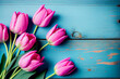 Leinwandbild Motiv Wunderschöne rosa Tulpen auf blauen Holztisch mit Platzhalter. Perfekter Hintergrund für den Frühling, Valentinstag, Ostern, Geburtstag, Hochzeit, Muttertag und Weltfrauentag - Ai generiert
