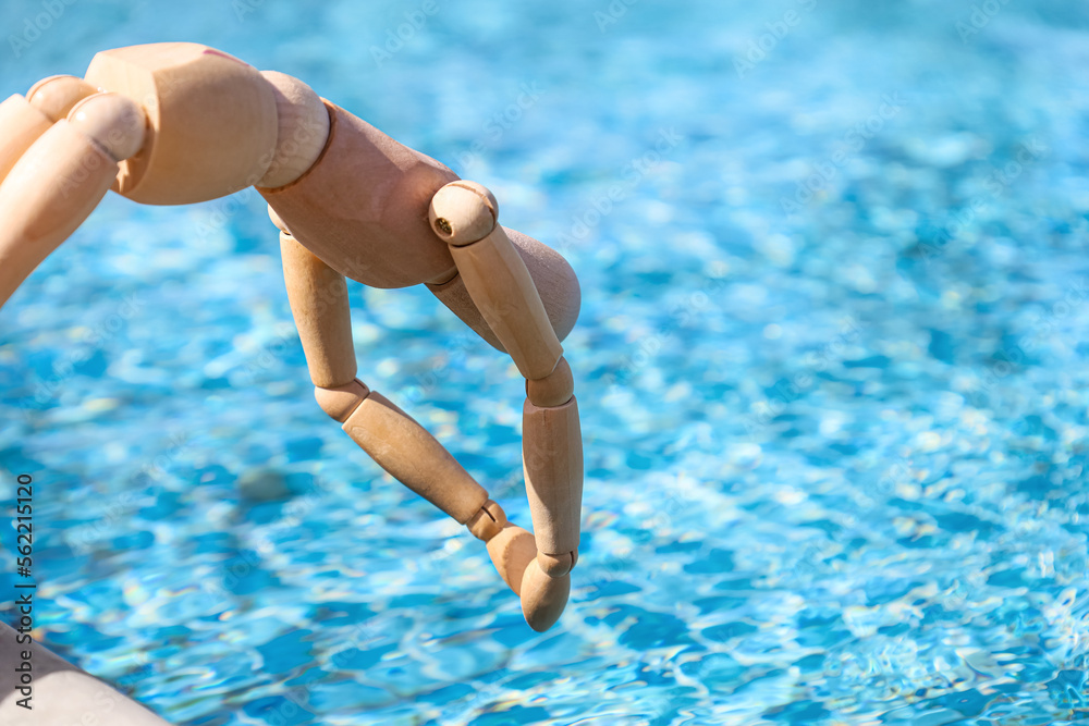 Wooden mannequin near swimming pool, closeup