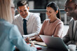 © Flamingo Images - Laughing businesspeople working together around an office table