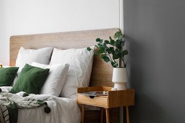 Poster - Vase with eucalyptus, devices and magazine on wooden table in bedroom