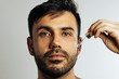 © kleberpicui - Middle-aged handsome man applying anti-aging face serum
