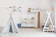 Stylish interior of children's room with baby bed and play tent