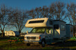 Motorhome and trailer parked at campsite in early morning sunrise