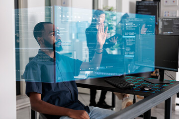 Wall Mural - African american programmer working with hologram checking data while creating security system. Using holographic image and new interface for cloud computing, database code programming.