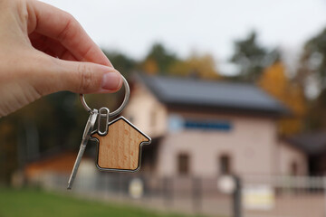 Wall Mural - Woman holding house keys outdoors, closeup with space for text. Real estate agent