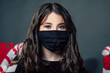 © Shotmedia - black face mask on a young teen girl which look at camera and protects herself from corona virus and bacterias