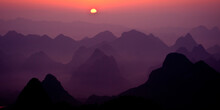Layers Of Karst Mountains In Early Morning Fog With The Sun Rising.  Gulilin, Guangxi, China.