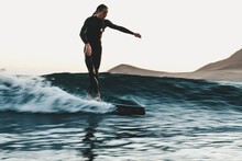 Surfer In Sea At Sunset