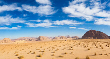 A Jeep Overlooks The Desert And Sandstone Cliffs Of Wadi Rum, Jordan.