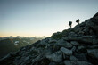 © Cavan Images - Silhouette of two male hikers at sunset with mountains in background