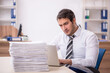 © Elnur - Young male employee unhappy with excessive work in the office