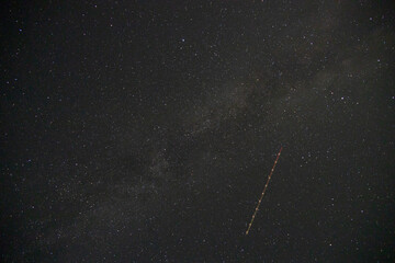Wall Mural - Satellite trail passing through the milky way, night-sky