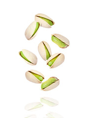 Poster - Pistachio nuts flying in the air isolated on white background.