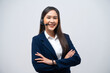 Beautiful Asian call center operator wearing a headset and microphone standing with her arms crossed isolated on grey background.