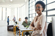 © Grady R/peopleimages.com - Leader, black woman and office portrait with business people for success, vision and smile at web design agency. Creative woman, leadership and modern office by blurred background for career goals