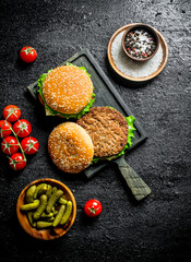 Sticker - Burgers on a cutting Board with gherkins and spices in bowls.