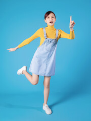 Wall Mural - Full length photo of young Asian girl standing on blue background