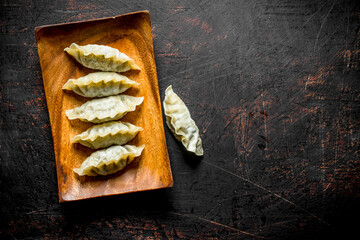 Poster - Raw gedza dumplings on wooden plate.