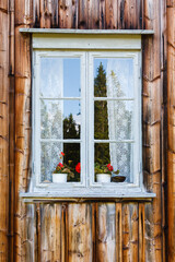 Wall Mural - Blooming geraniums in the window of the old cottage