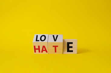 Love vs Hate symbol. Wooden cubes with words Hate and Love. Beautiful yellow background. Valentines Day and Love vs Hate concept. Copy space