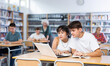 © JackF - Boy and girl study together at laptop while sitting in a school library