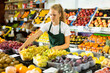 © JackF - Young salesgirl at her first job, selling green grape and other fruits in vegetable shop