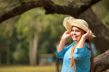 Wall Mural - Young indian woman wearing hat and giving expression at park