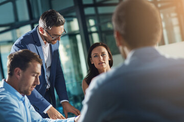 Business people, meeting and talk for strategy, planning and success with teamwork, vision and leader. Businessman, leadership and group at desk with woman, man and discussion while sitting in office