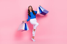 Full body length size photo of overjoyed shopaholic lady wear blue blouse fist up hold bags new cheap clothes isolated on pink color background