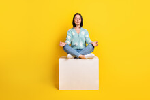 Full Size Photo Of Positive Good Mood Woman Dressed Blue Pullover Sit On Cube Meditating Eyes Closed Isolated On Yellow Color Background