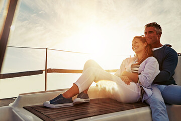 Hug, sunset and couple on a yacht for travel, retirement holiday and ocean adventure in Spain. Investment, hobby and man and woman on a boat for a luxury cruise, sailing and happiness at sea