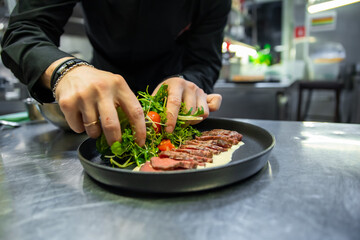 Sticker - chef hand cooking Roast beef salad with vegetables on restaurant kitchen