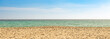 Panoramic wide view of an empty  sand beach with sea and blue sky by a sunny day. Seascape background with copy space