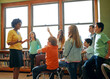 © Reese/peopleimages.com - Learning, education and student with questions for teacher in middle school classroom. Library, scholarship group and male learner raising hand to answer question, studying or help with black woman.