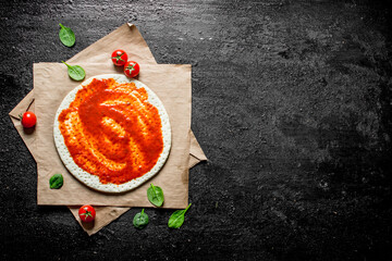 Sticker - Preparation pizza. Rolled out dough with tomato paste.