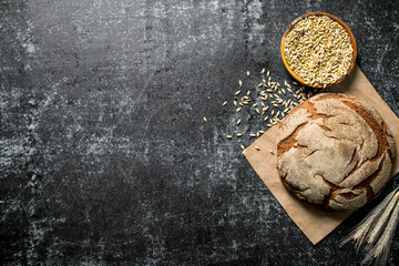 Wall Mural - Fragrant bread on paper with grains and spikelets.