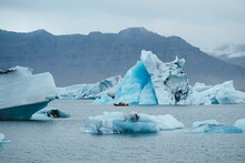 Boat Floating In Sea Near Icebergs