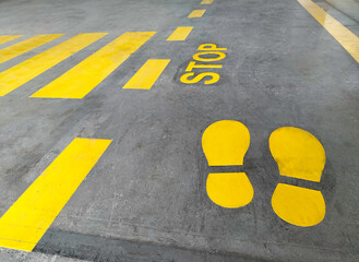 Walkway signs and painted yellow on the factory floor. scratched cement surface industrial safety sign