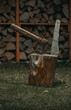 axe in the stump with background of wooden wall