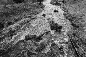 Little river through the lonely and cold countryside (b/w)