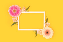Frame Made Of Green Leaves, Alstroemeria And Gerbera Flowers On A Yellow Background.